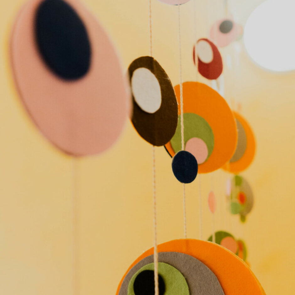 Telpas rotājums no krāsainiem filca apļiem.