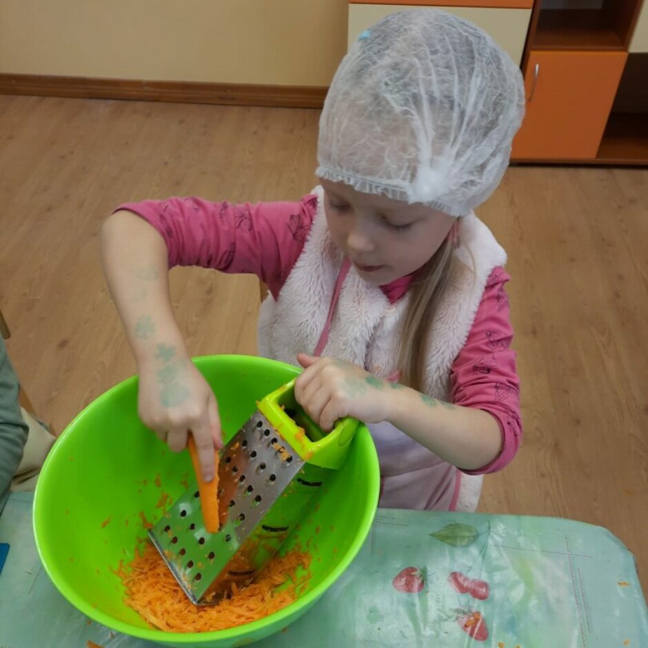 Meitene rīvē burkānu.