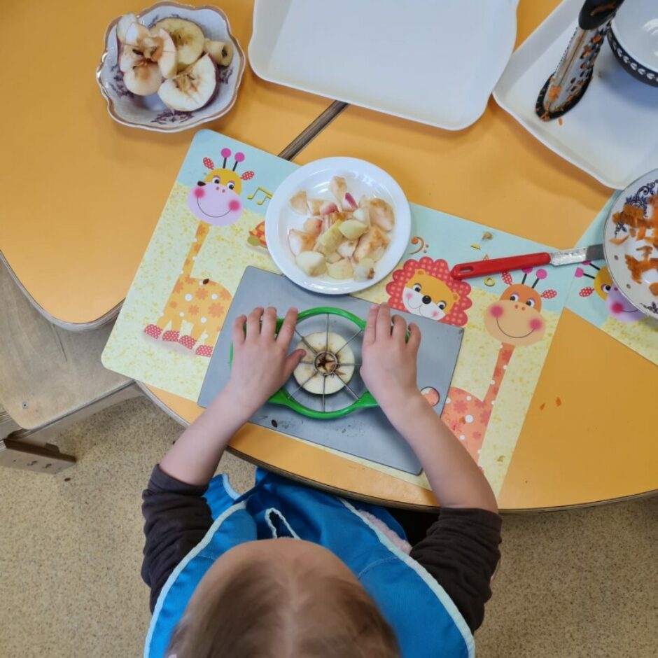 Meitene griež gabaliņos ābolu.