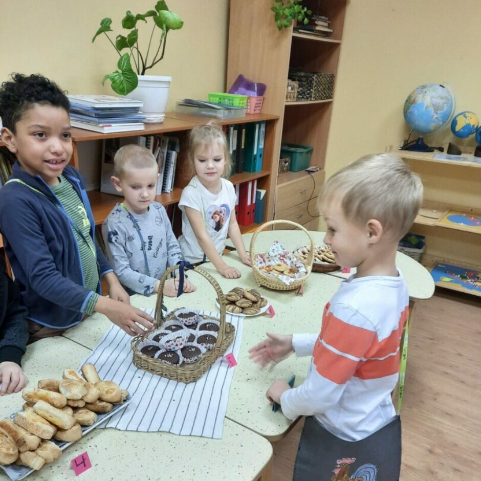 Zēns izvēlas gardumus no Mārtiņdienas tirdziņa galda, kurus nopirkt.