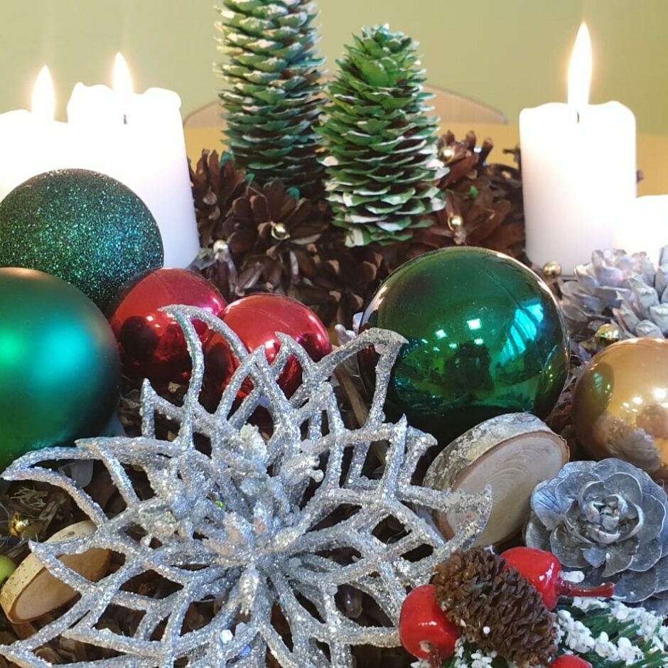 Pašu gatavots Adventes vainags no čiekuriem un krāsainiem rotājumiem.