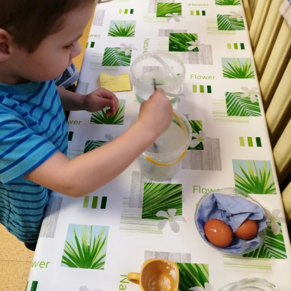 Bērns ar karoti iemaisa sāli ūdenī.