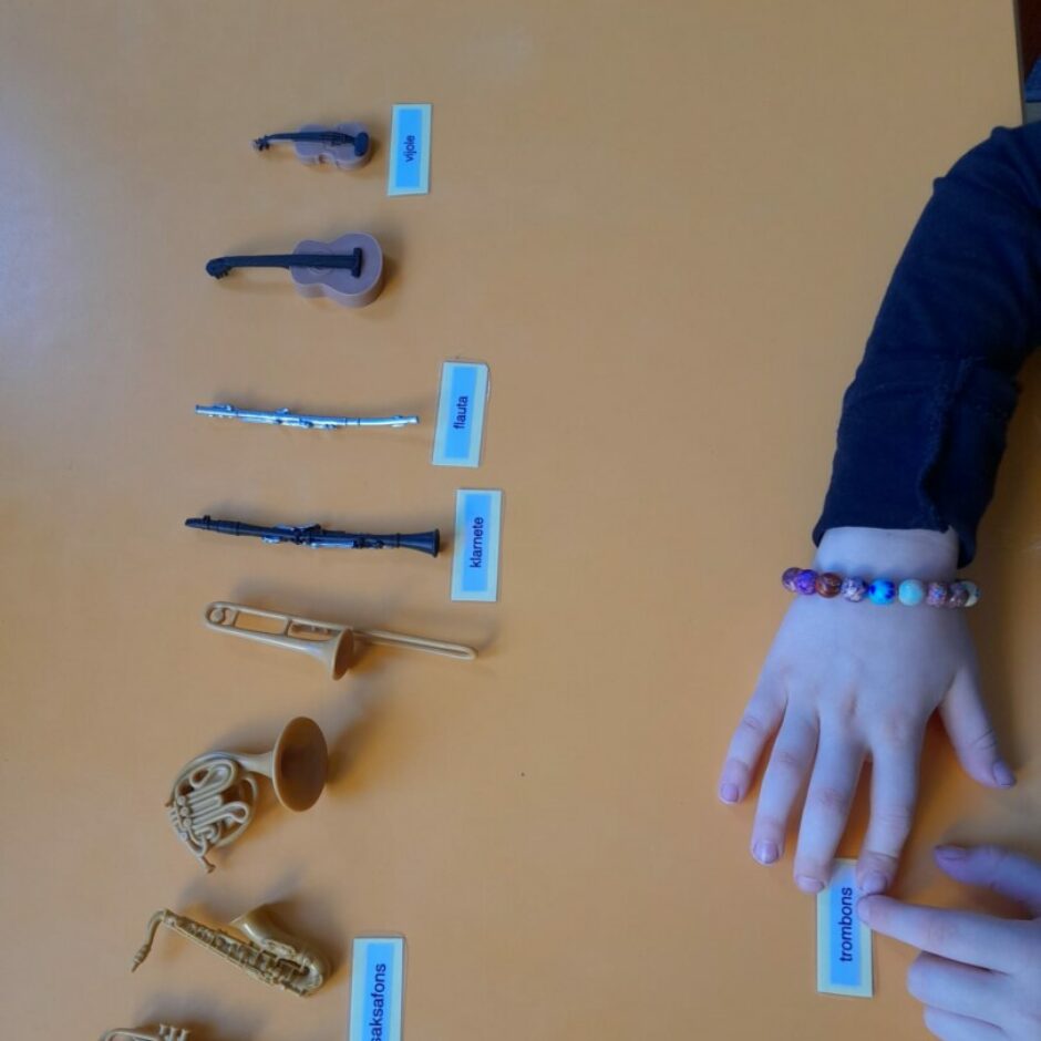 Bērns pie galda darbojas ar materiālu 