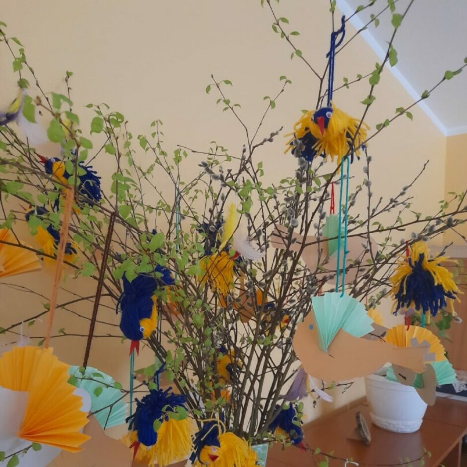 Bērnu veidoti putniņi no dzijas un papīra rotā pirmsskolas grupu.