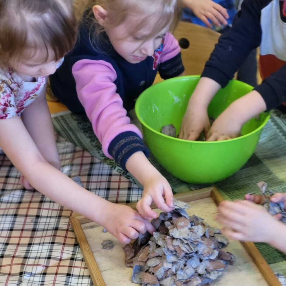 Bērni pie galda veido stilizētu skudrupūzni.
