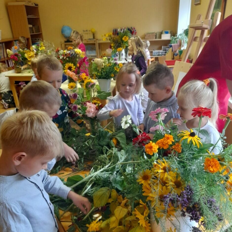 Bērni pie galda veido kompozīcijas