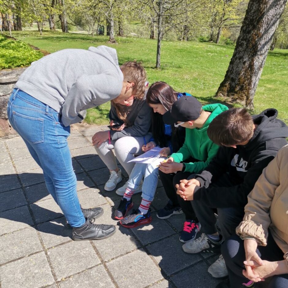 Meitenes un zēni ārā uz soliņa