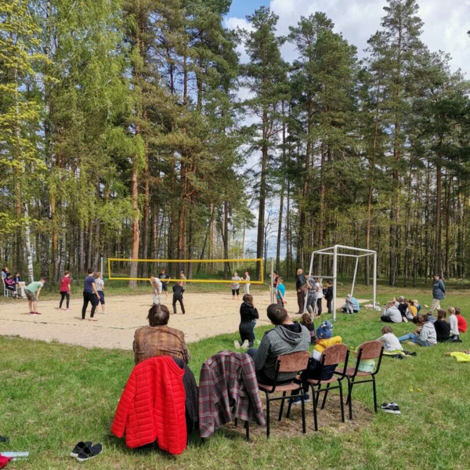 Sievietes un vīrieši spēlē volejbolu