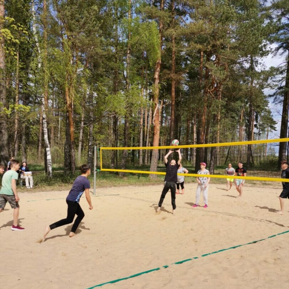 Sievietes un vīrieši spēlē volejbolu
