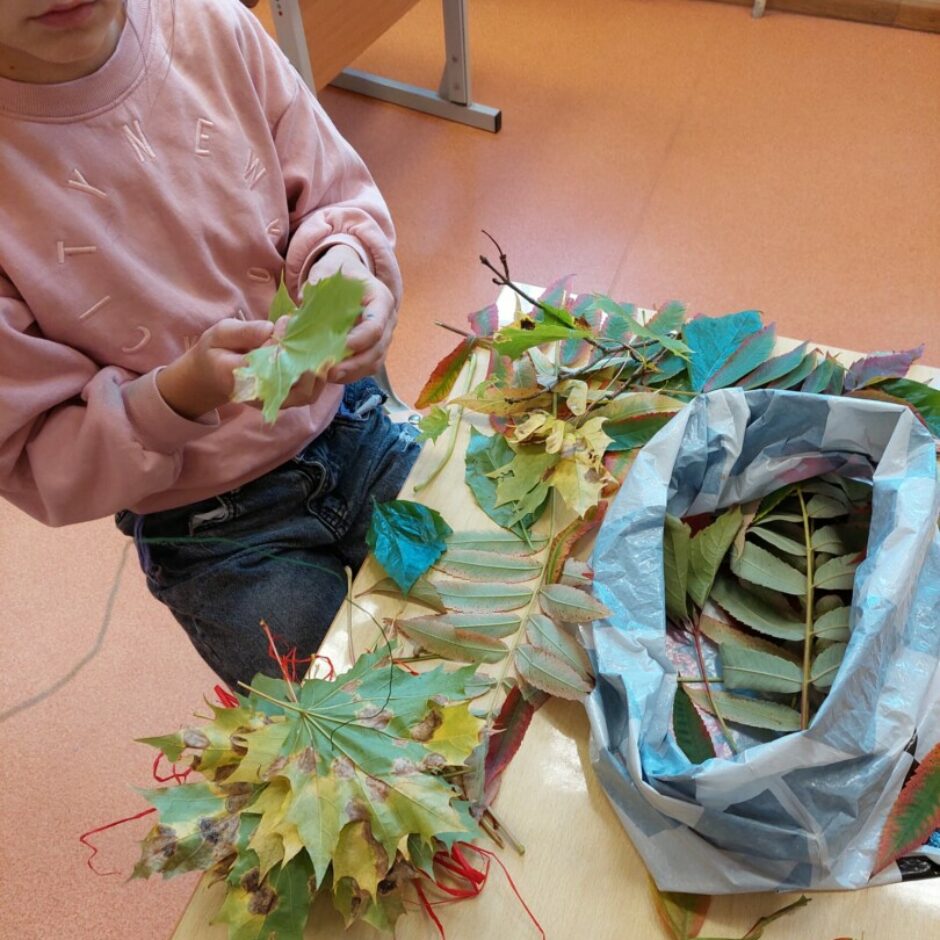 bērns spēlējas ar koka lapām