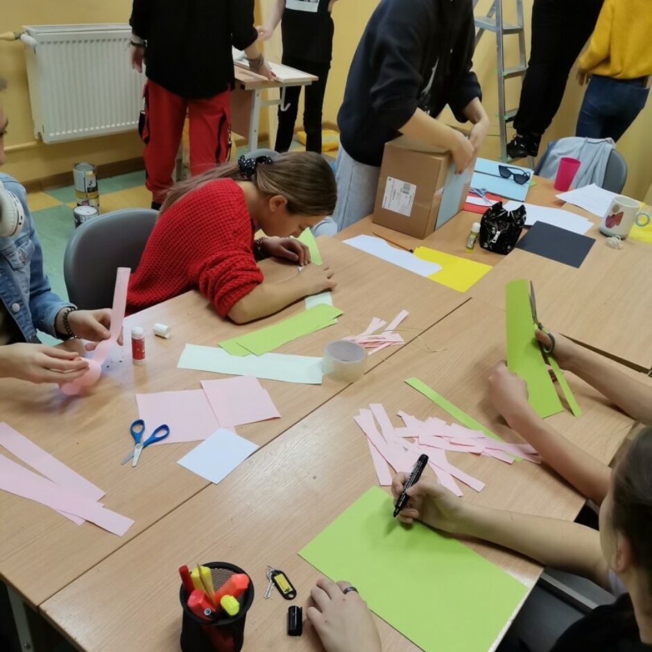 Bērni pie galda griež papīru