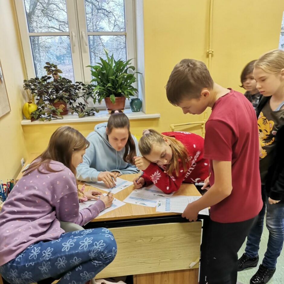 Bērni pie galda raksta