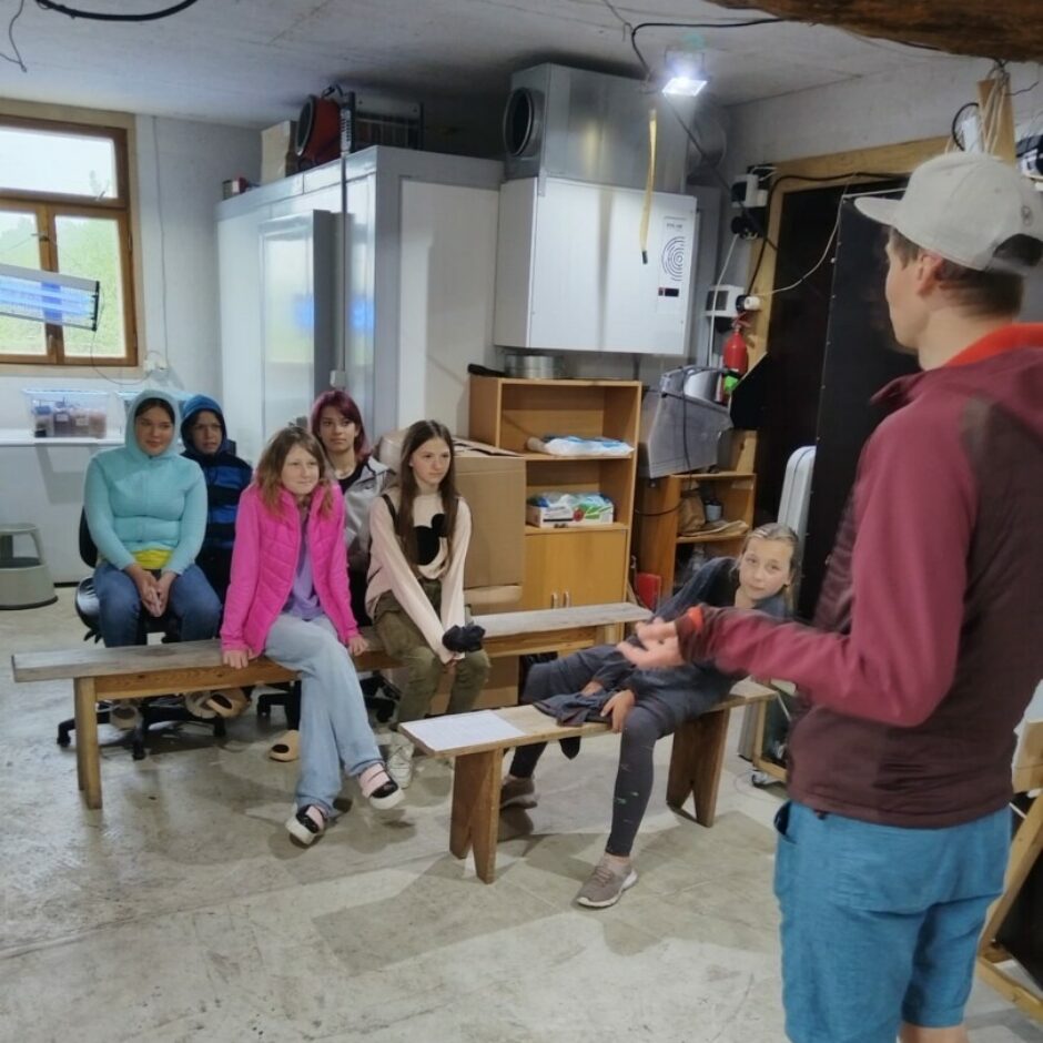 Bērni sēž, vīrietis stāv