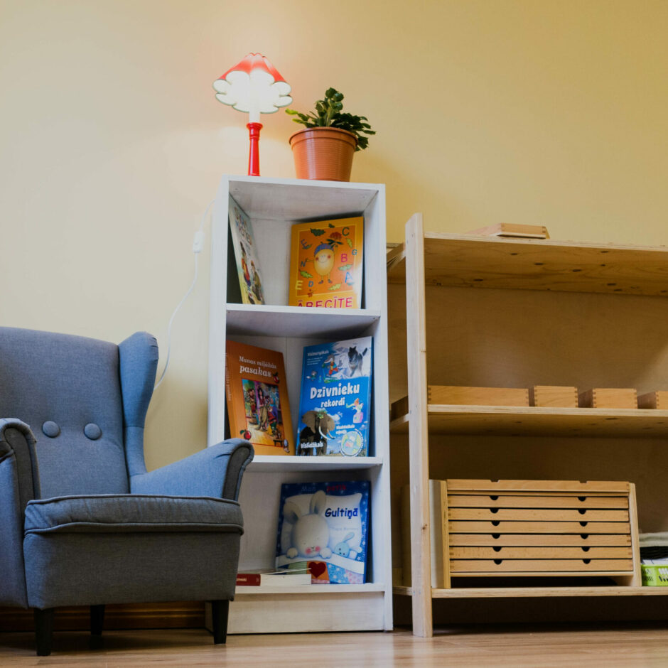 Lasīšanas stūrītis ar grāmatu plauktu un ērtu krēslu.