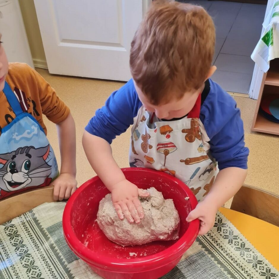 Zēns mīca mīklu maizei.