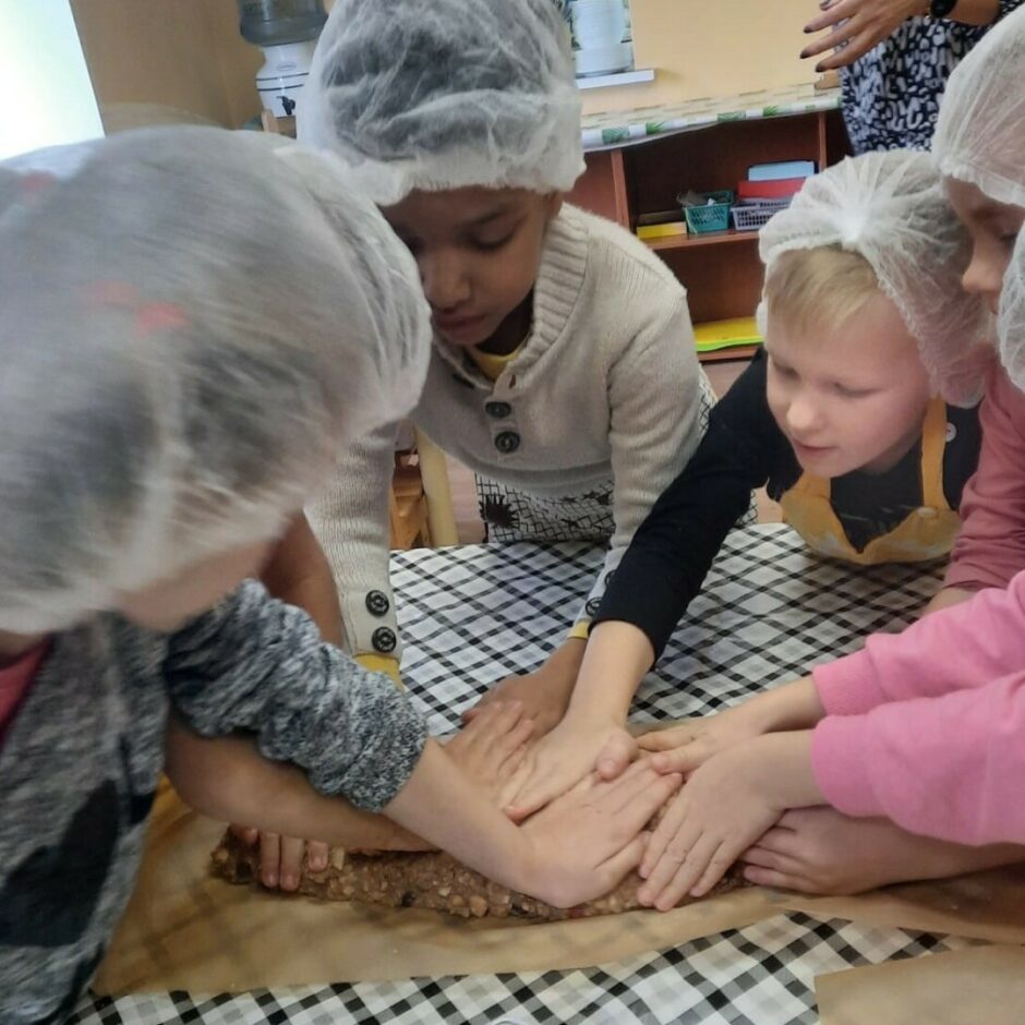 Bērni veido ruletes formu no pašu pagatavotās saldās masas.