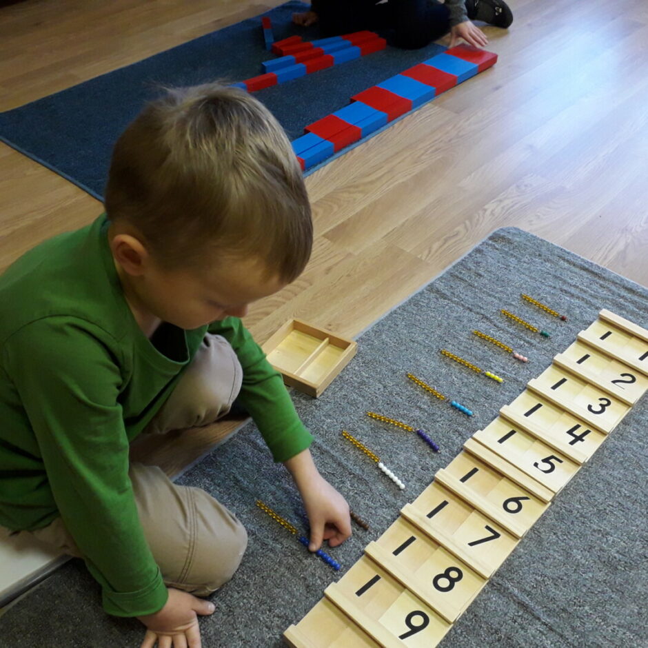 Zēns darbojas ar Montesori materiālu 