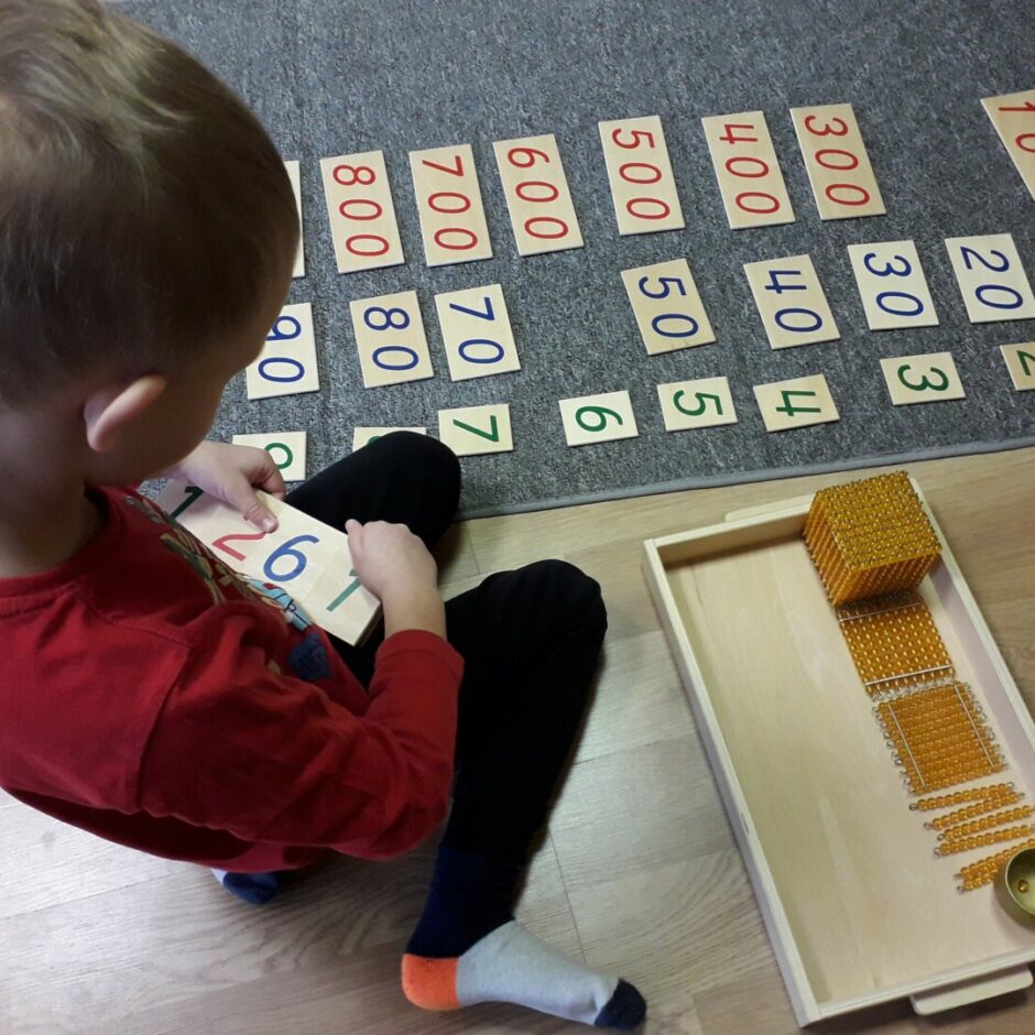 Zēns darbojas ar Montesori materiālu 