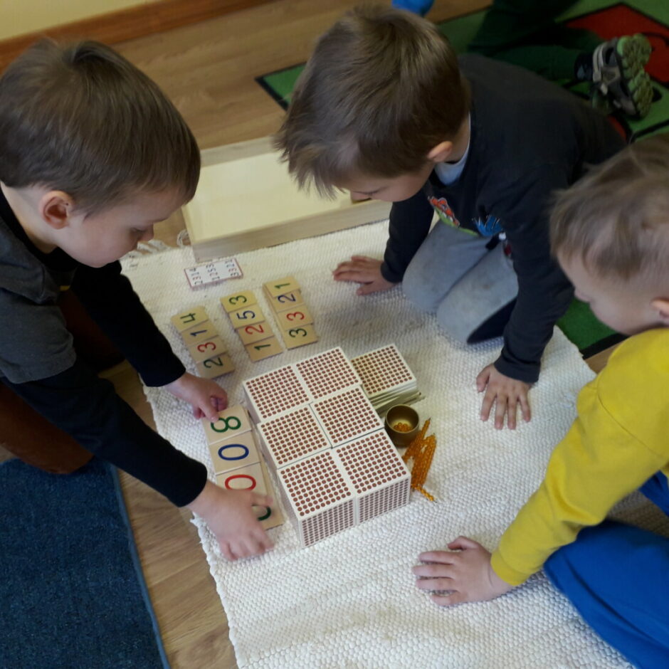 Trīs zēni veic saskaitīšanu ar Montesori 
