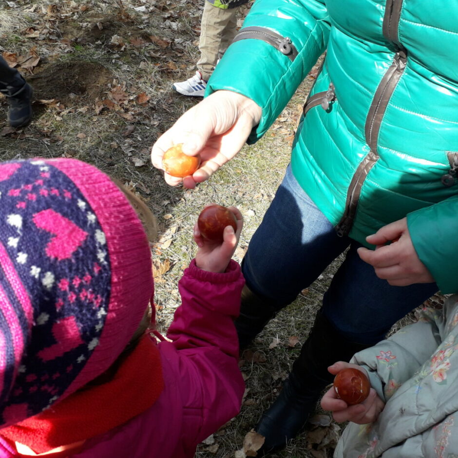 Bērni un skolotāja sitas ar Lieldienu olām.