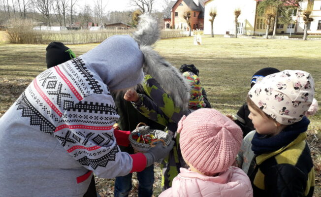 Lieldienu zaķis bērnus cienā ar saldumiem.