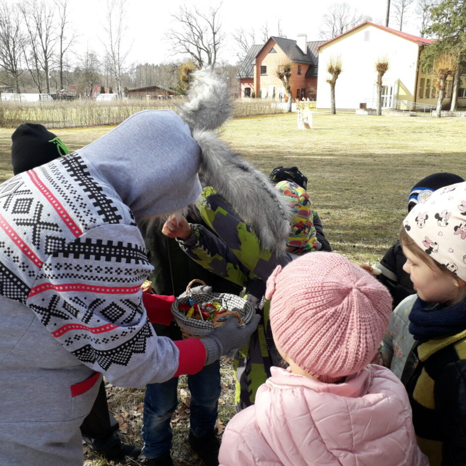 Lieldienu zaķis bērnus cienā ar saldumiem.