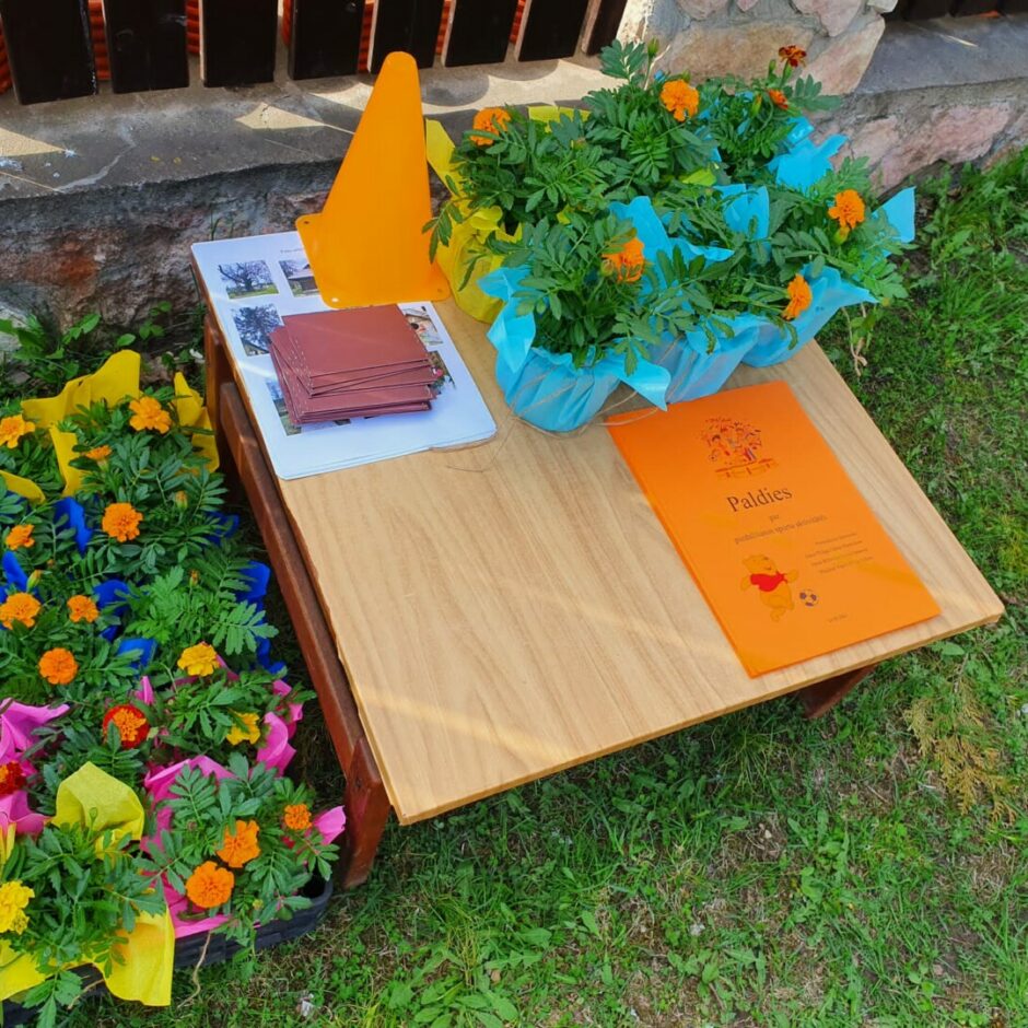 Ziedi un diplomi gaida apbalvošanu.