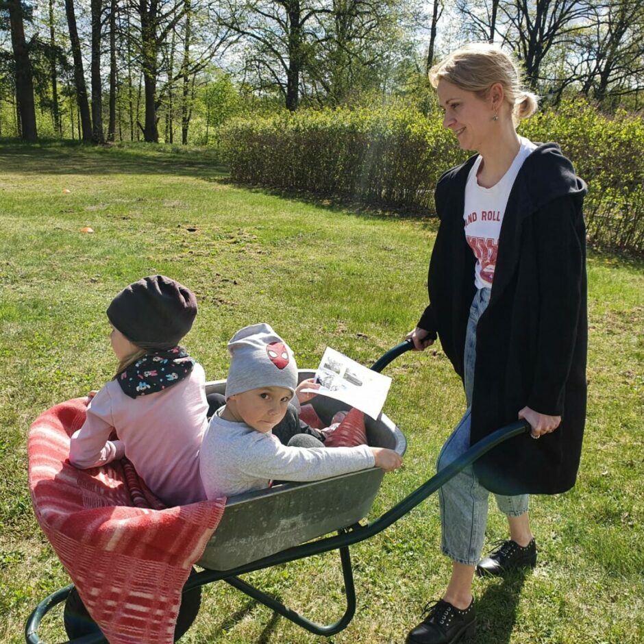 Mamma stumj divus bērnus ķerrā.