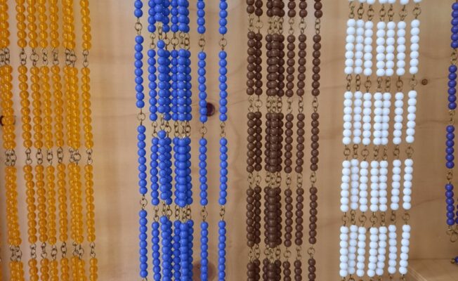 Montesori pērlu virtenes statīvā