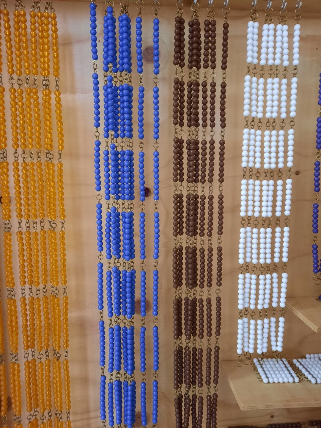 Montesori pērlu virtenes statīvā