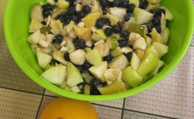 Augļu salāti zaļā bļodā, ābols un citrons