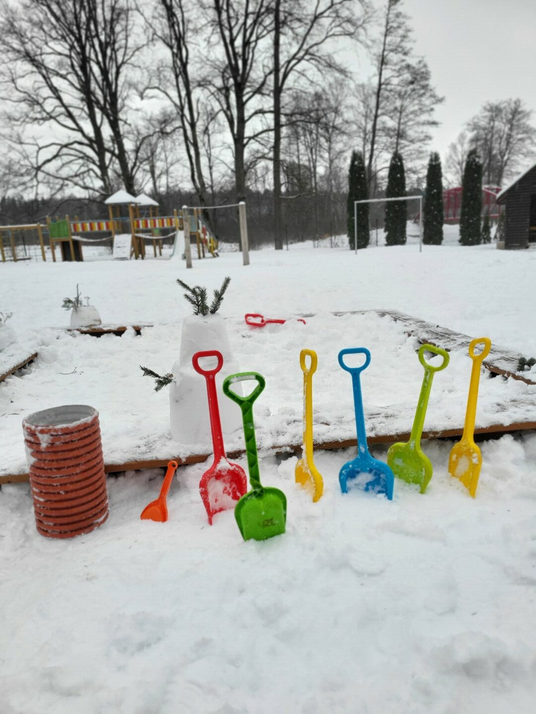 Krāsainas sniega lāpstiņas iedurtas baltā sniegā
