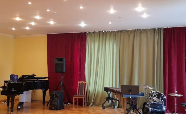 Zāle ar klavierēm un bungām