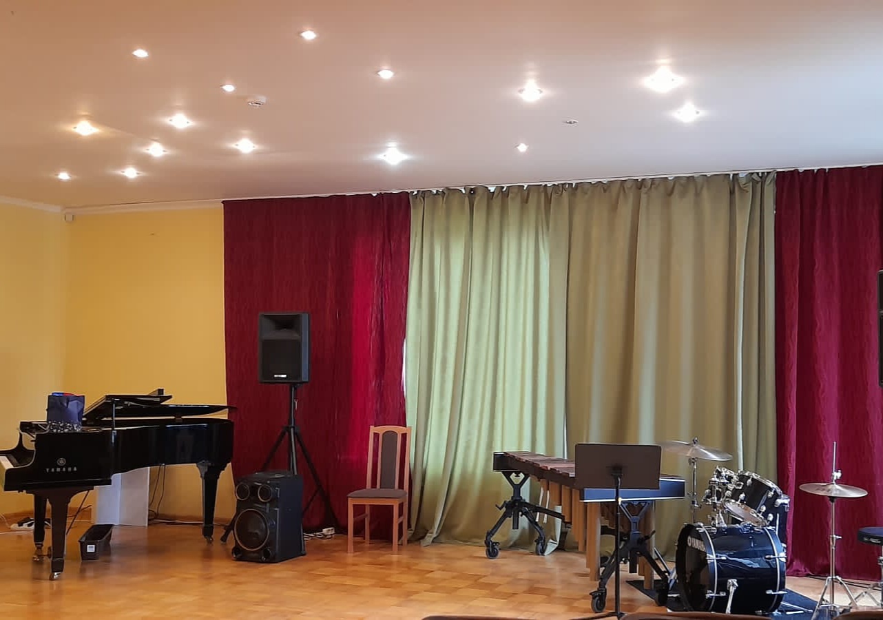 Zāle ar klavierēm un bungām