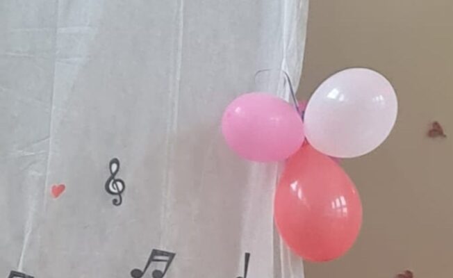 Trīs rozā baloni pie baltas sienas