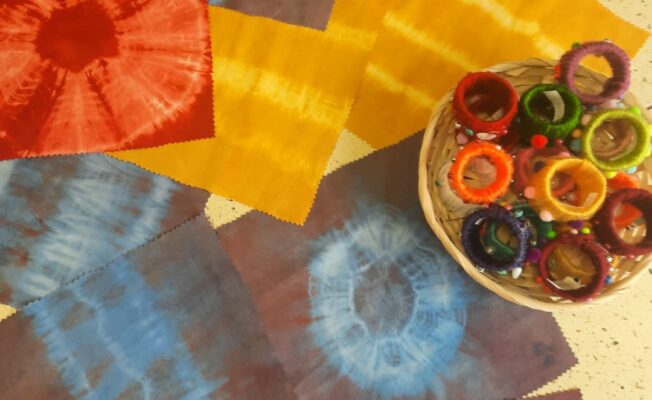 Batikotas salvetes uz galda un salvešu turētāji groziņā.