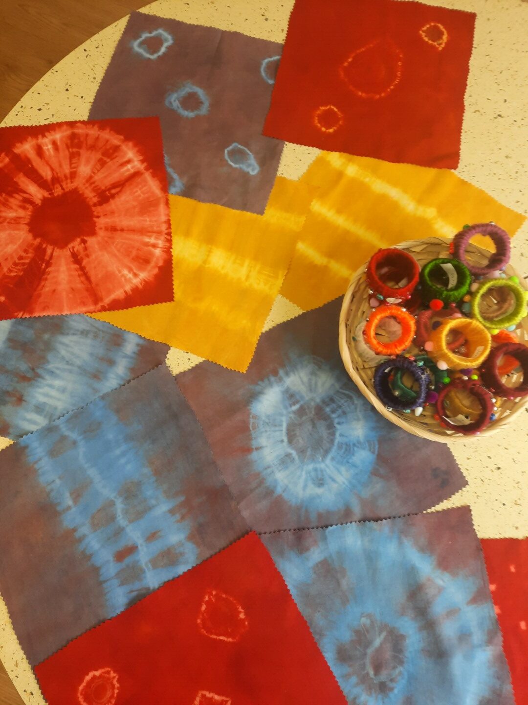 Batikotas salvetes uz galda un salvešu turētāji groziņā.