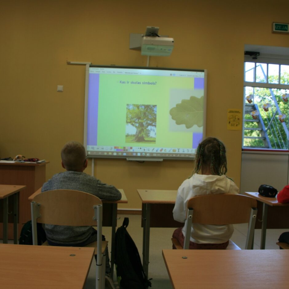4 skolēni klasē vēro prezentāciju