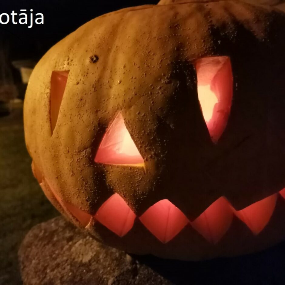 Izgrebts ķirbis tumsā