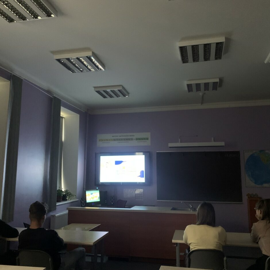 Divi zēni un divas meitenes skatās tiešsaistes lekciju.