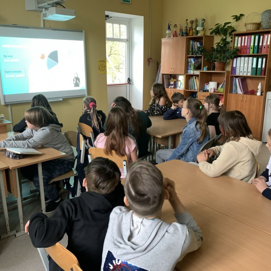 Skolēni sēž klasē un klausās lekciju.