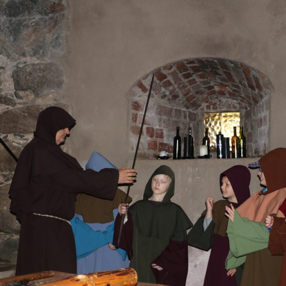 3 bērni un pieaugušais mūka tērpos