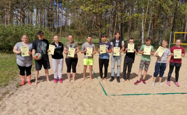 Sievietes un vīrieši volejbola laukumā