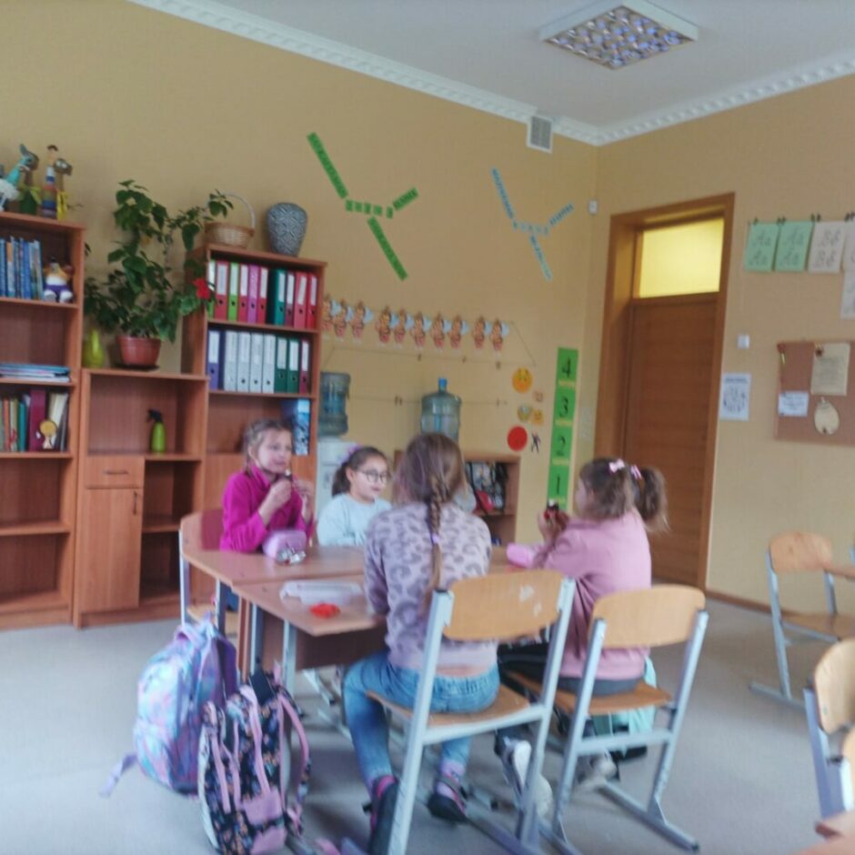 Bērni sēž klasē pie galda