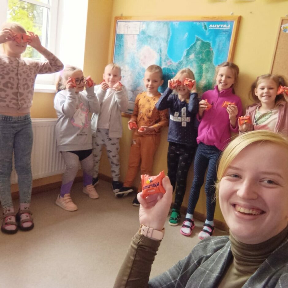 Bērni stāv klasē kopā ar skolotāju