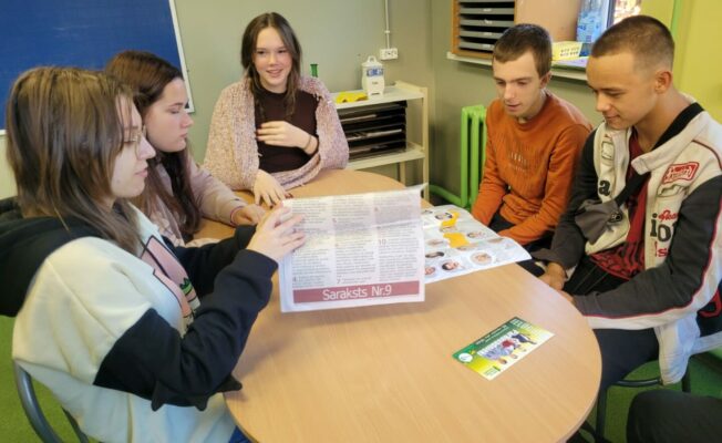 Skolēni sēž pie galda