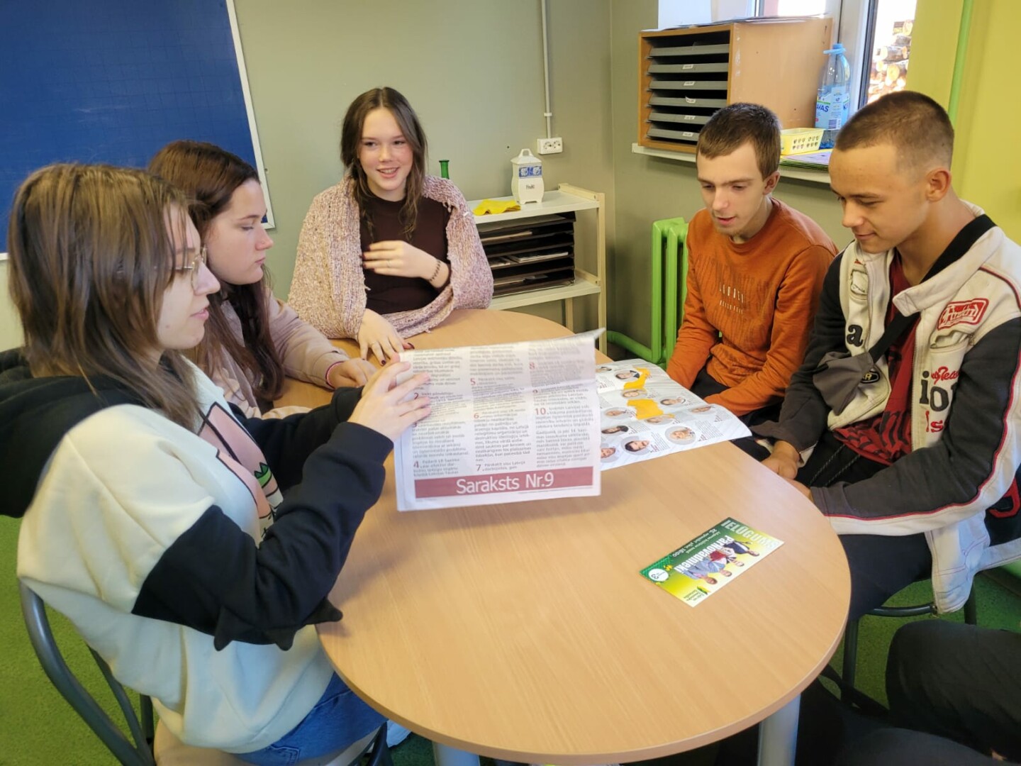 Skolēni sēž pie galda