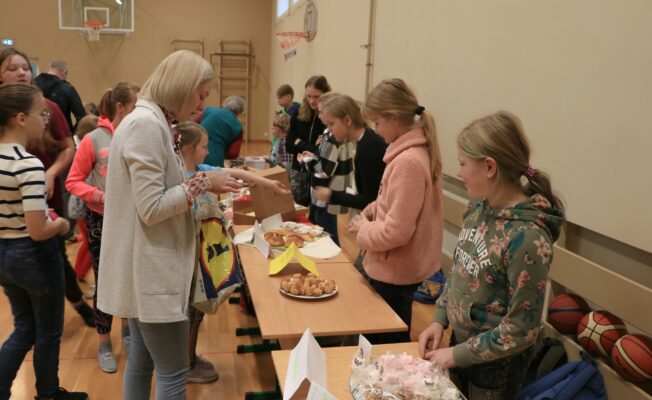 Bērni un skolotāja pie galda