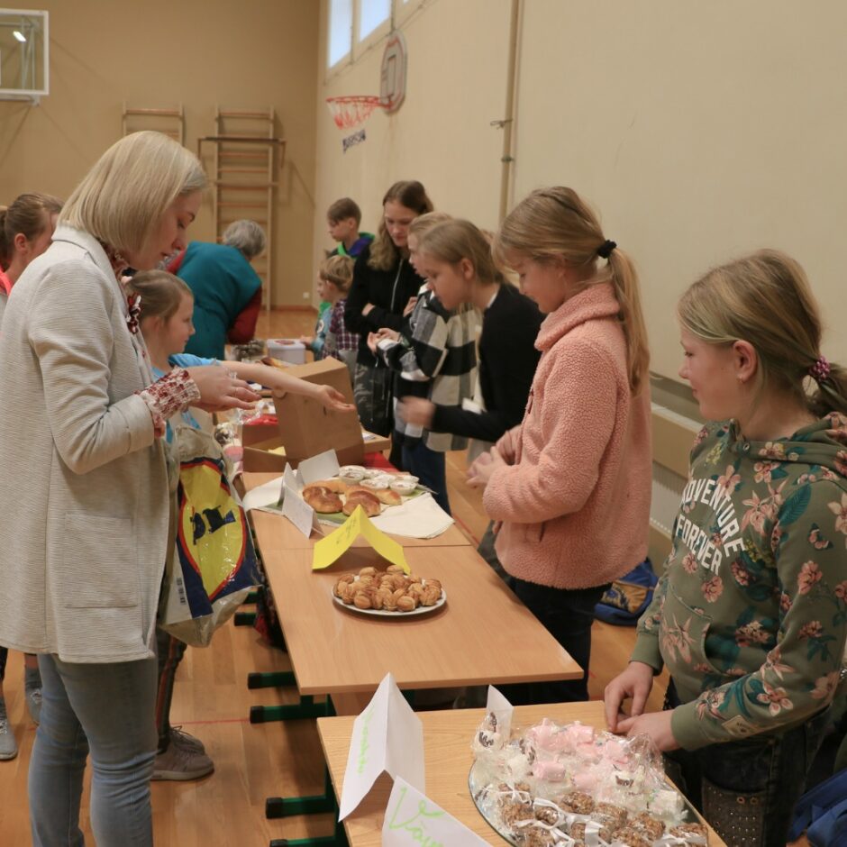 Bērni un skolotāja pie galda