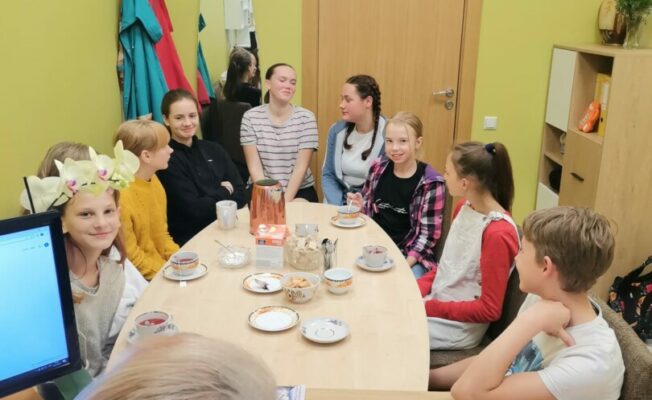 Skolēni pie glada dzer tēju